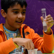 A child holds a test tube from Letterbox Lab.