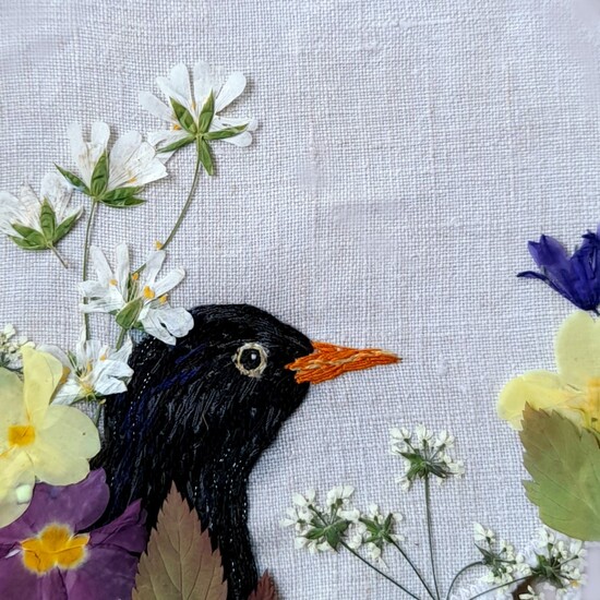 hand embroidered blackbird and pressed flowers