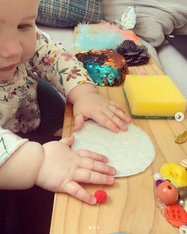 6 month old baby playing with a sensory board