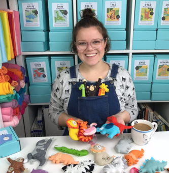 Bea, founder of the brand Bea Kind, holding various felt animals