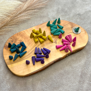  Colourful assortment of naturally scented incense cones. Eco friendly incense placed beautifully on a wooden board with a incense burner plate.