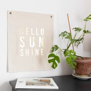 A fabric screenprinted banner, in gold foil with 'hello sunshine'