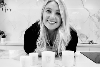 Image of founder Alice, in Black and White in front of products 