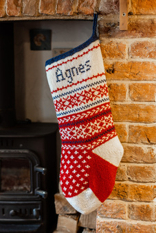 Red and white knitted Christmas Stocking with snowfalkes and hand embroideredd name in cross stitch