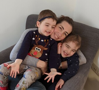 Lauren, owner, cuddling her two smiling children