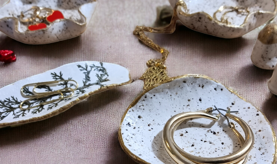 A selection of tiny clay dishes with jewellery on them
