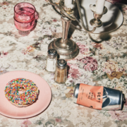 A crushed can of DEFY organic rosé wine on a table next to a doughnut.