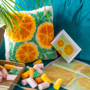 Kit for when life gives you oranges and completed latch hook cushion on turquoise sofa 