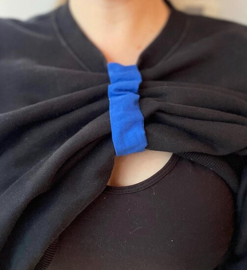 a breastfeeding scrunchie holding up a black top