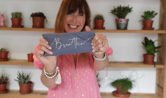 Lucy, Founder smiling holding blue breathe eye pillow