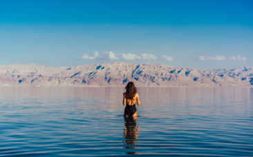 Young woman going into the Dead Sea