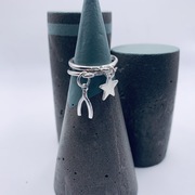sterling silver wishbone charm stacking ring stacked alongside a sterling silver star charm stacking ring 