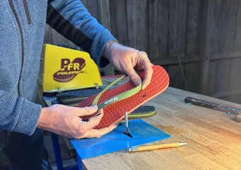 A pair of red and green flip flops being hand made in the UK