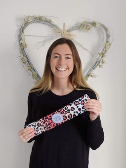 Founder of Perky Booty holding leopard print short fabric resistance band