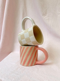 Two geometric pattern mugs stacked up on top of each other.