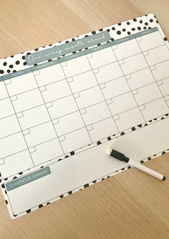 A black and white spotty monyhly planner with the titles in a sage green colour