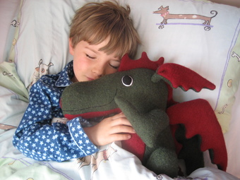boy asleep with soft toy dragon by cdbdi