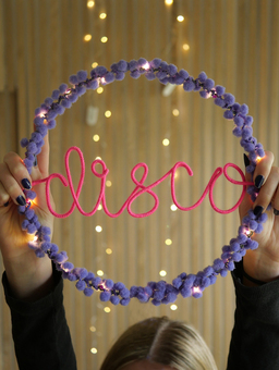 Personalised disco hoop light with lilac pom poms and neon pink writing