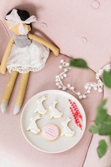 Childrens biscuits with candles, bunny rabbits and a dolly with pom poms
