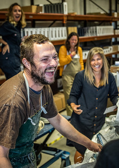 4 people from Green&Blue are shown laughing in the companies cornish workshop