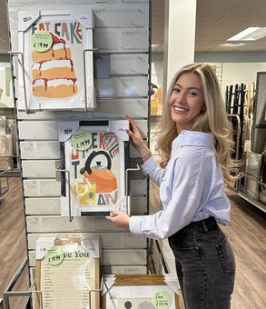 Me holding a framed print that is for sale in Homesense high street store