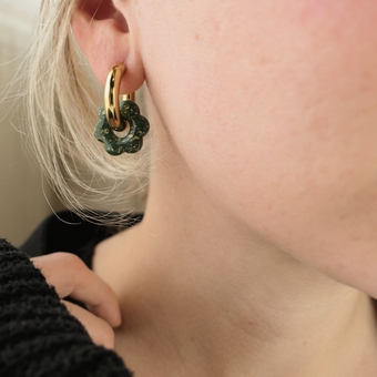 Chunky gold hoop earrings in an ear