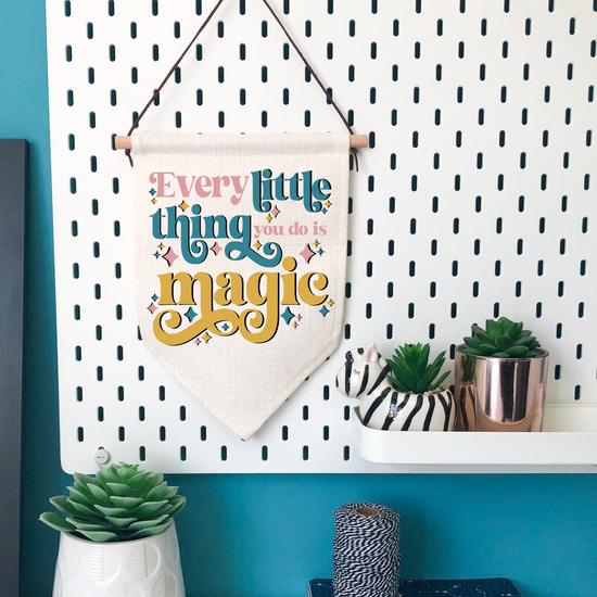 Every Little Thing You Do Is Magic printed on a hanging banner decoration in an office