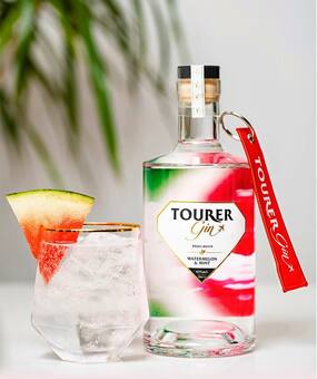 Tourer gin - watermelon gin bottle shot alongside a gin and tonic garnished with watermelon slice.