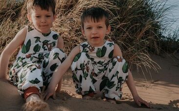 2 boys in zac and bella orangutans rompers on a sand dune